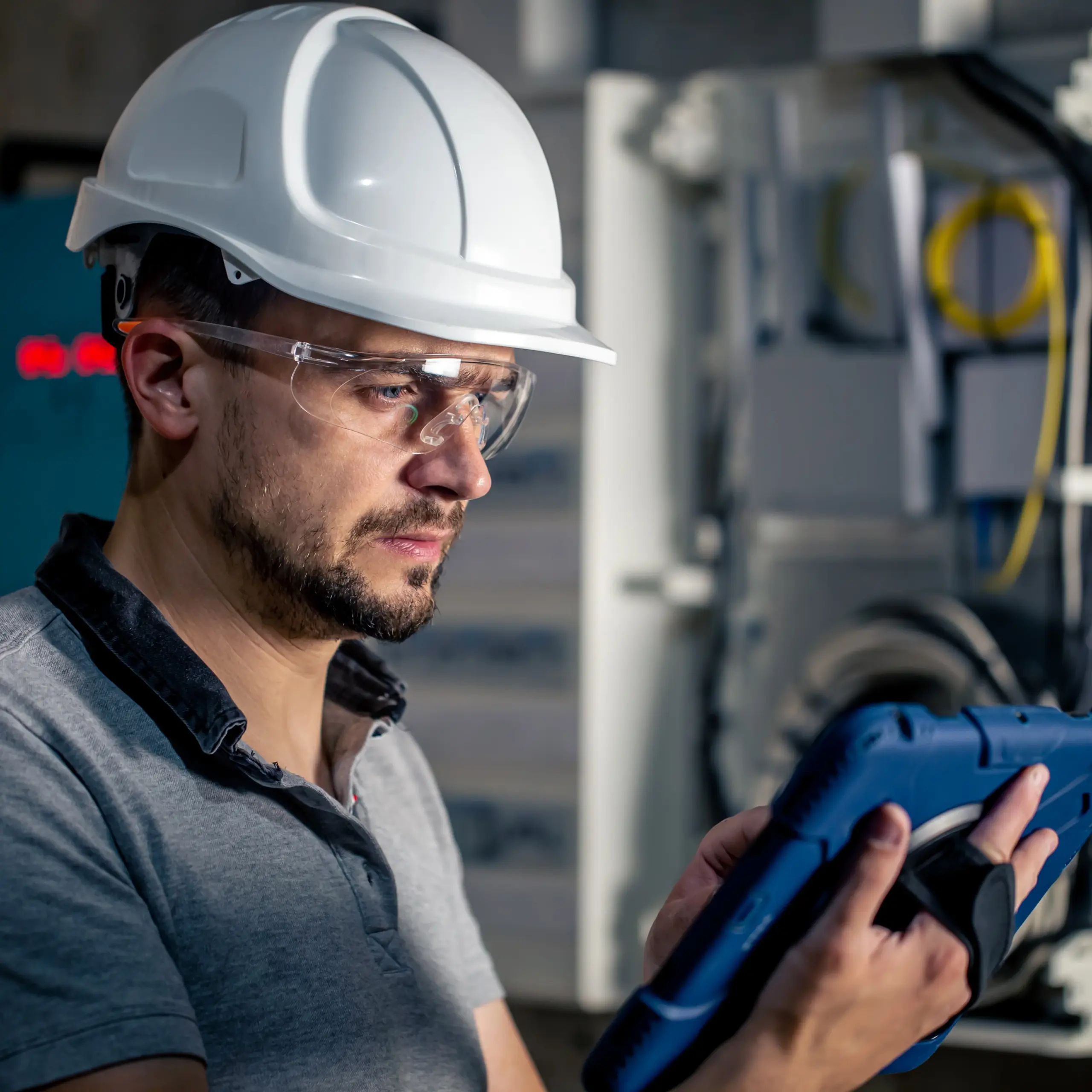 man-electrical-technician-working-switchboard-with-fuses-uses-tablet